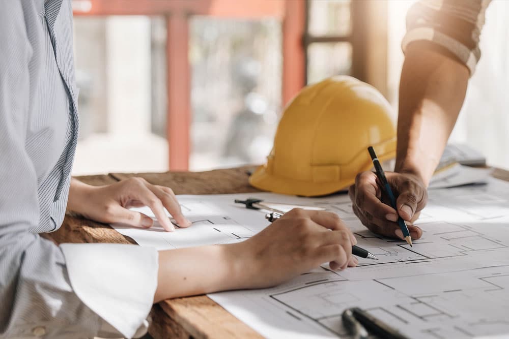 Workers writing on blueprint